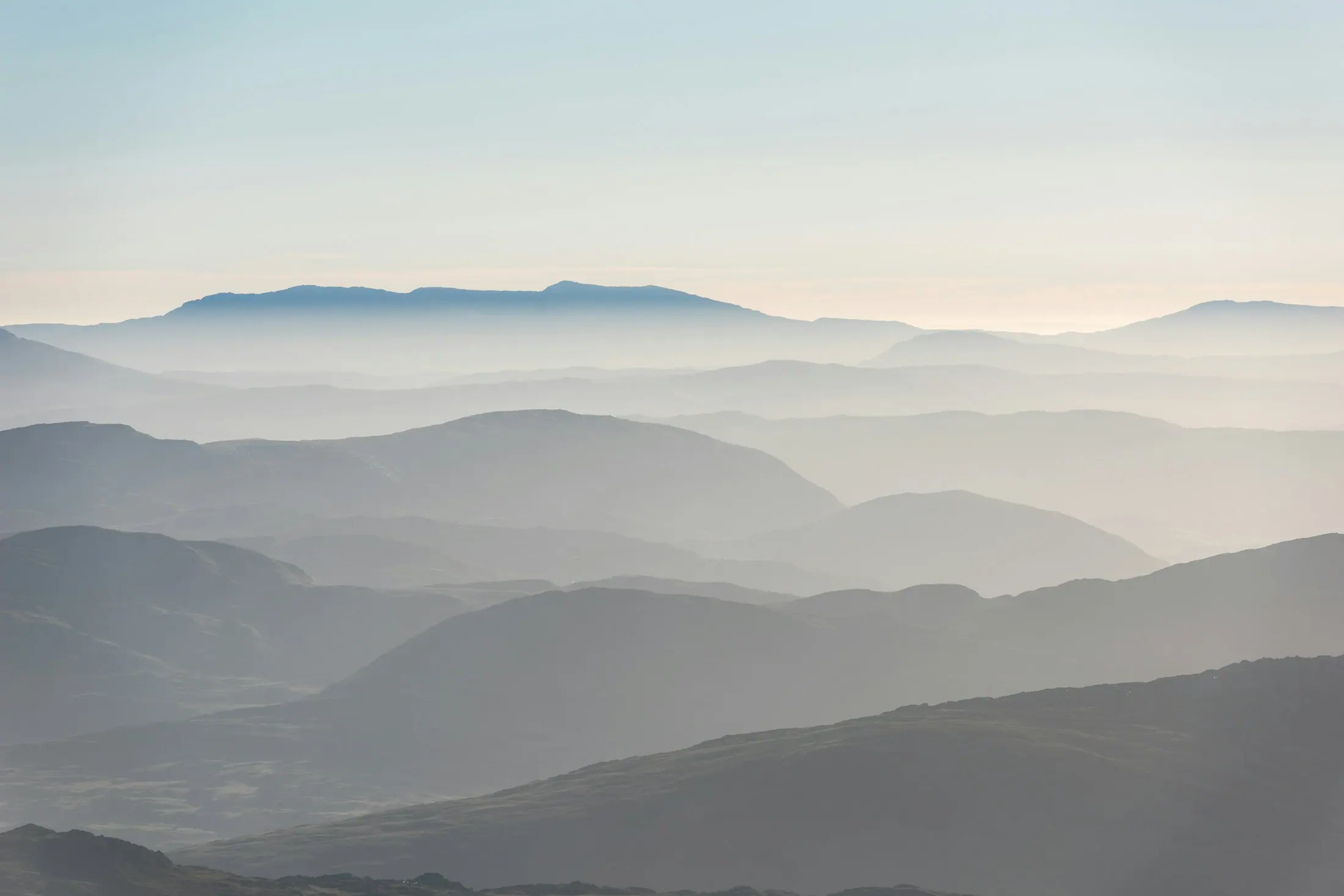 Layered hills under a soft sunrise