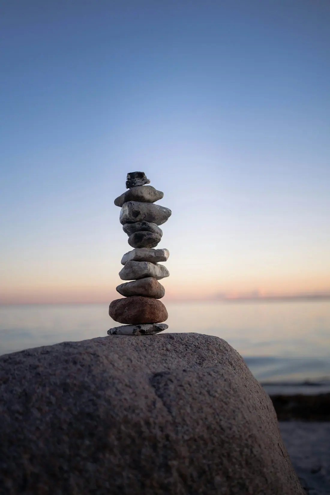 Balanced stones resting beside still water