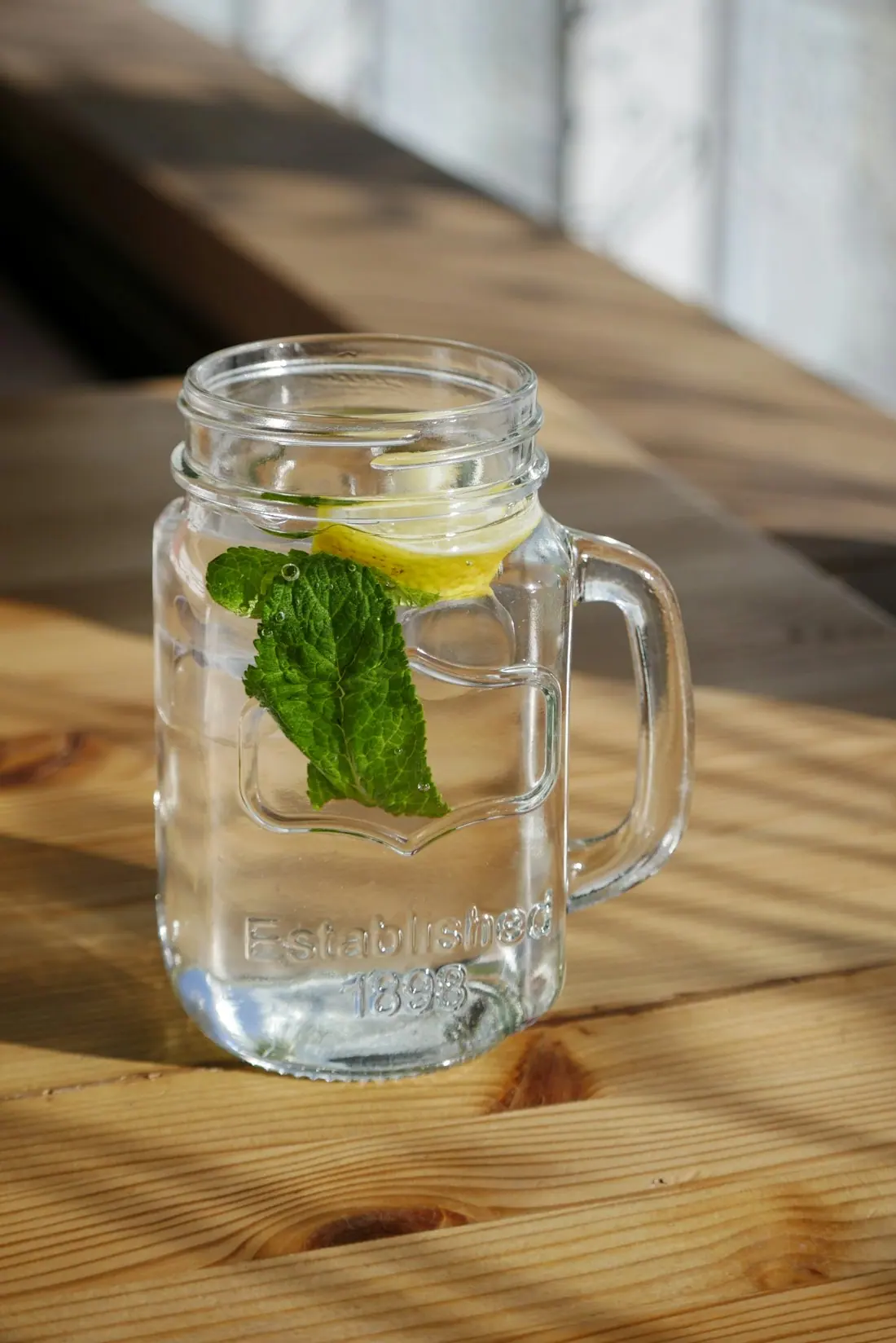 A herbal infusion in a clear glass with fresh leaves