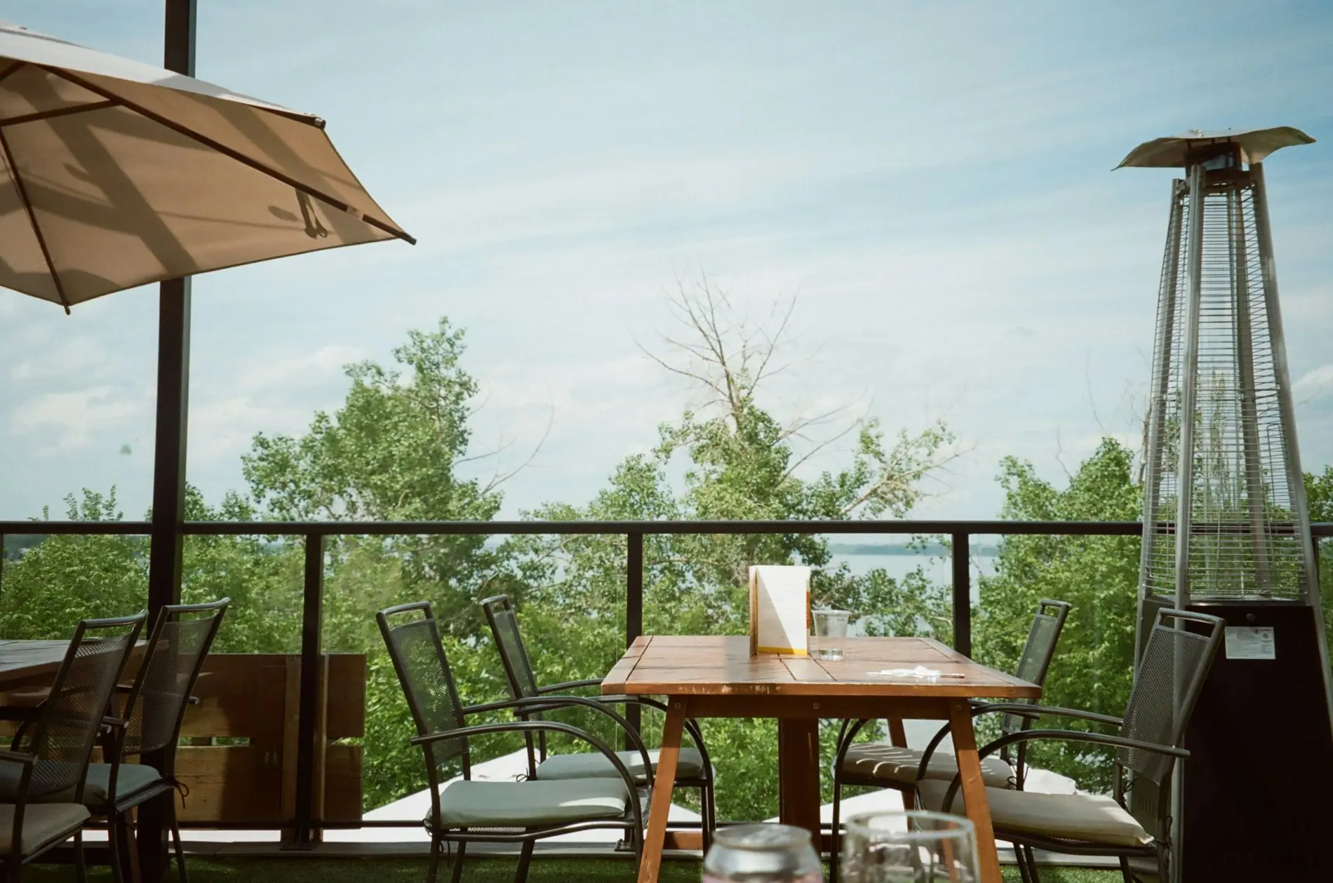 A dining table set beside a window looking onto greenery